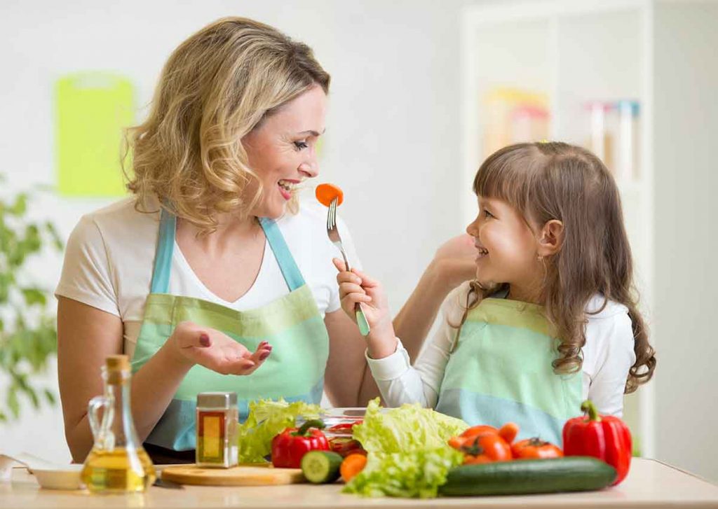Daughter feeding a carrot to her mother